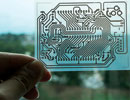 A single-sided wiring pattern for an Arduino microcontroller printed on a transparent sheet of coated PET film.